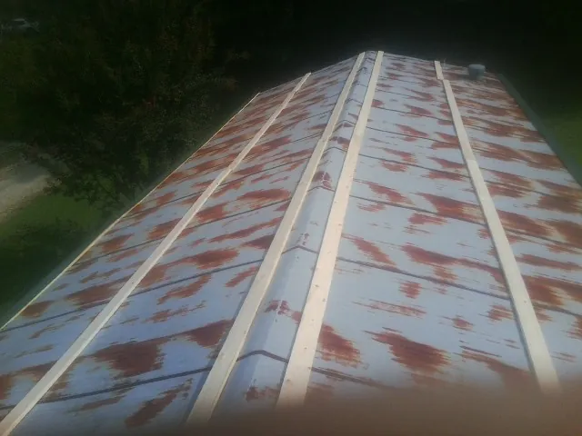 Rusted metal roof panels with new wood purlins before replacement — Storm Damage Roof Repair in Exline by Roofing Brothers