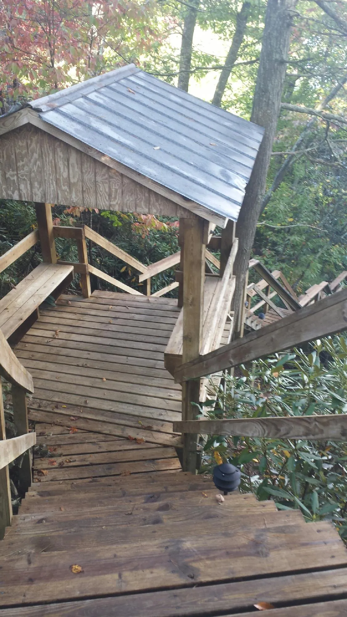 Metal roofed shelter over wooden steps on a wooded walkway — Skylight Repair & Installation work by our crew in Exline