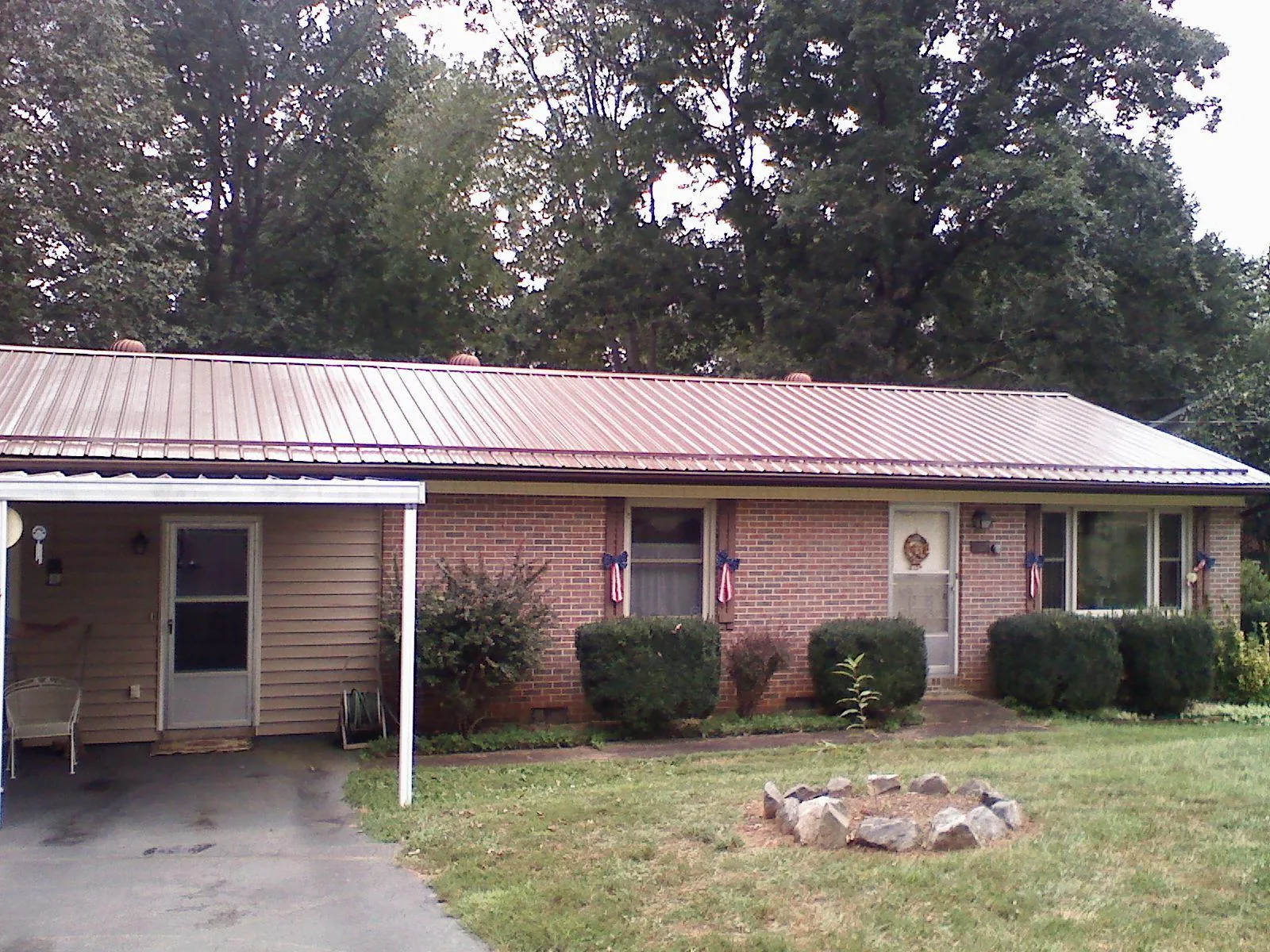 Bronze metal roof and carport on a brick ranch home — Roof Repair work by our crew in Exline