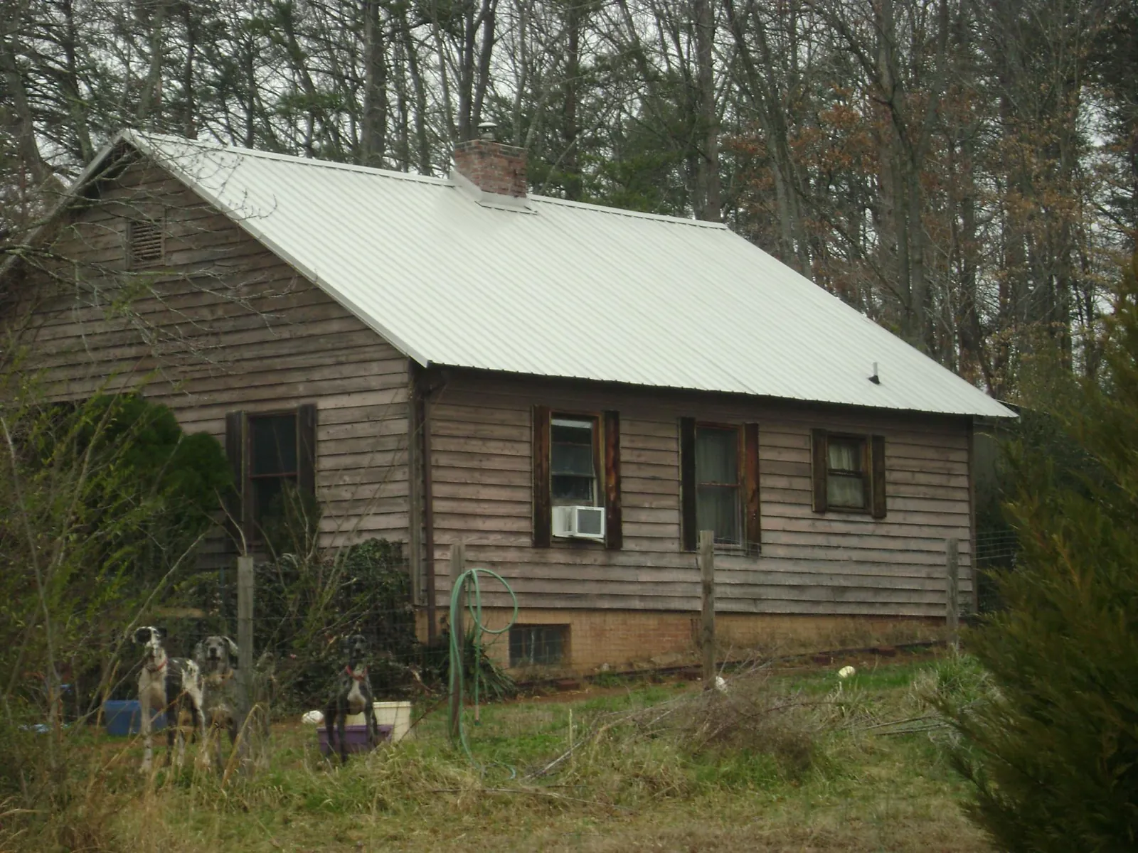 White metal roof on an old wood sided farmhouse, from a Metal Roof Installation job in Exline